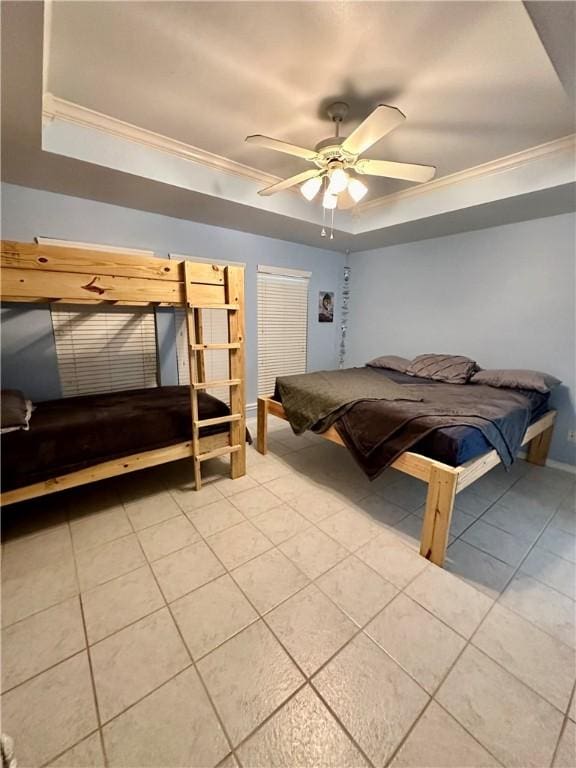 bedroom featuring light tile patterned floors, a tray ceiling, ceiling fan, and crown molding