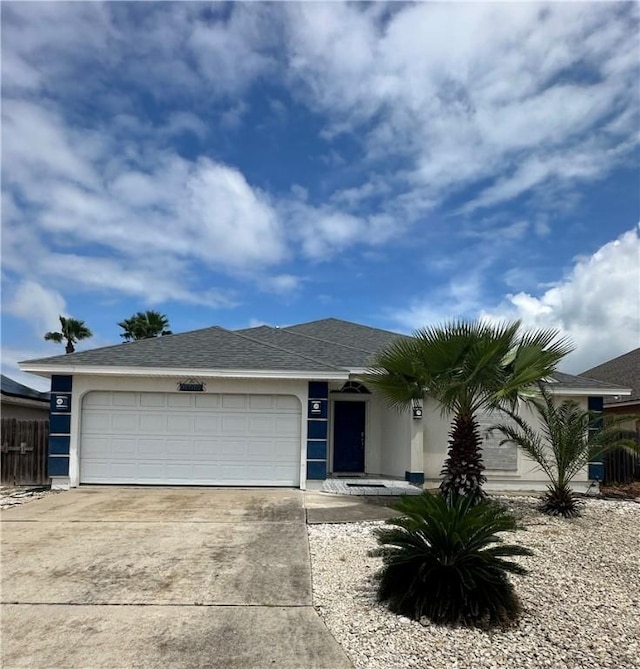 view of front of house with stucco siding, concrete driveway, a garage, and roof with shingles