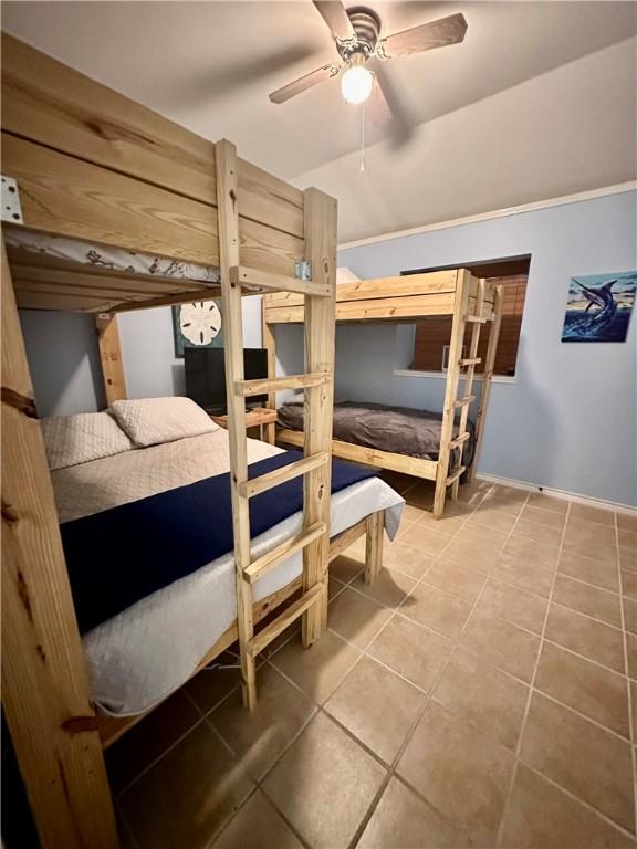 tiled bedroom featuring ceiling fan