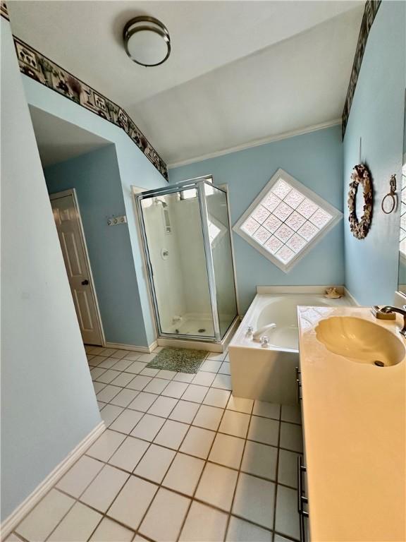 bathroom with tile patterned flooring, a shower stall, baseboards, a garden tub, and vanity