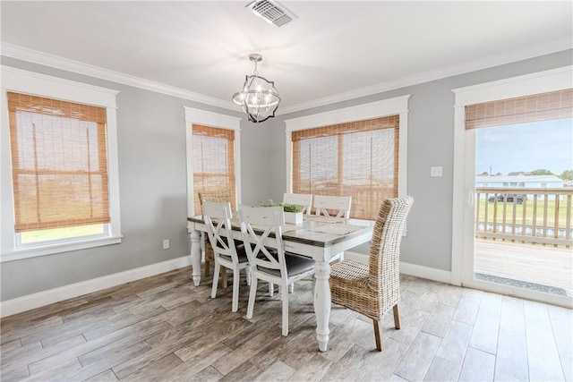 356 E Sagebrush St, Rockport, TX 78382 - dining room with a chandelier, light wood-type flooring, plenty of natural light, crown molding, and baseboards