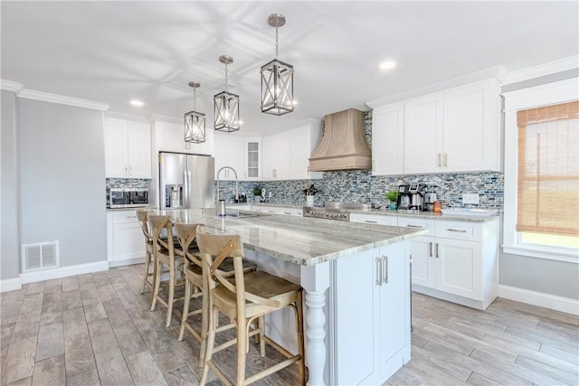 356 E Sagebrush St, Rockport, TX 78382 - kitchen featuring custom range hood, appliances with stainless steel finishes, a sink, a chandelier, and backsplash