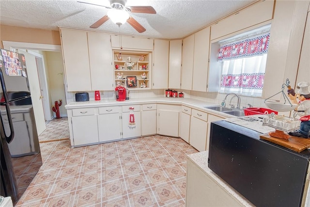 kitchen featuring white cabinetry, sink, ceiling fan, and a textured ceiling