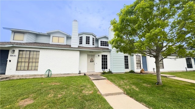 3014 Quail Spgs # D5, Corpus Christi, TX 78414 - view of front of property featuring a chimney, brick siding, and a front yard