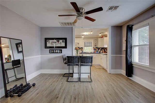 kitchen featuring light wood-type flooring, visible vents, and white cabinetry