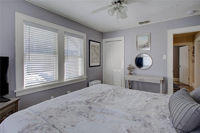 bedroom with a ceiling fan, a closet, visible vents, and attic access