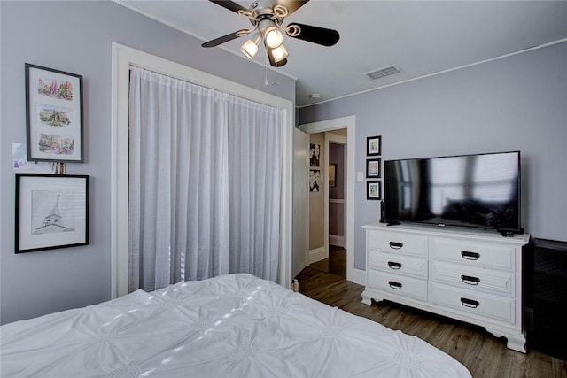 bedroom featuring ceiling fan, visible vents, and dark wood-type flooring