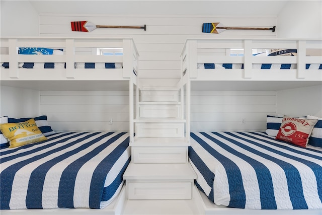 bedroom featuring wooden walls