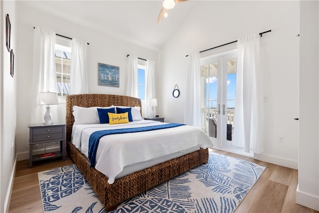 bedroom featuring access to outside, french doors, light hardwood / wood-style floors, and vaulted ceiling