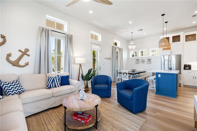 living room featuring ceiling fan and light hardwood / wood-style floors