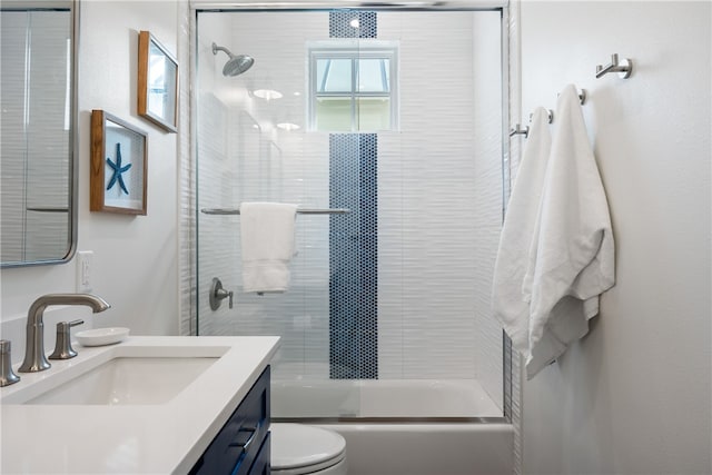 full bathroom with vanity, toilet, and combined bath / shower with glass door