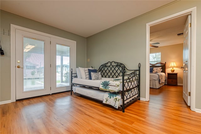 bedroom with access to outside, multiple windows, and light hardwood / wood-style flooring