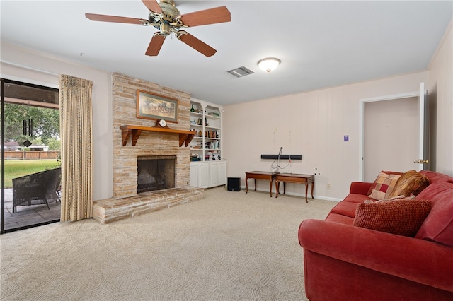 carpeted living room with a fireplace, ceiling fan, and built in features