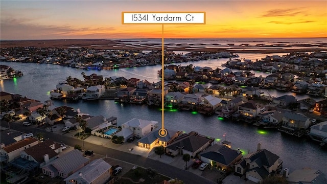 aerial view at dusk featuring a water view