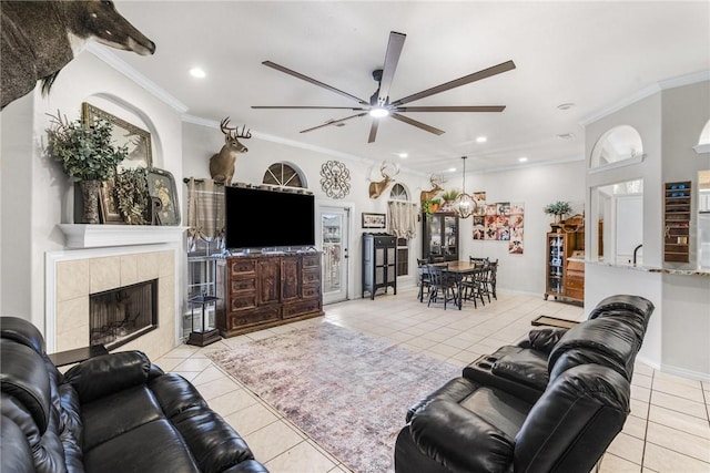 tiled living room featuring ceiling fan, ornamental molding, and a fireplace