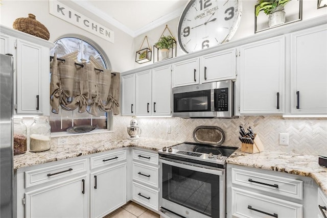 kitchen featuring white cabinetry, light stone countertops, backsplash, light tile patterned floors, and appliances with stainless steel finishes