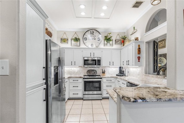 kitchen featuring light stone countertops, white cabinetry, stainless steel appliances, kitchen peninsula, and light tile patterned floors