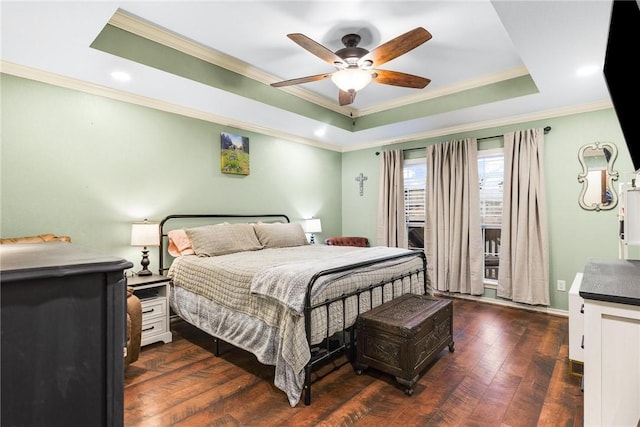 bedroom featuring ceiling fan, dark hardwood / wood-style floors, crown molding, and a tray ceiling