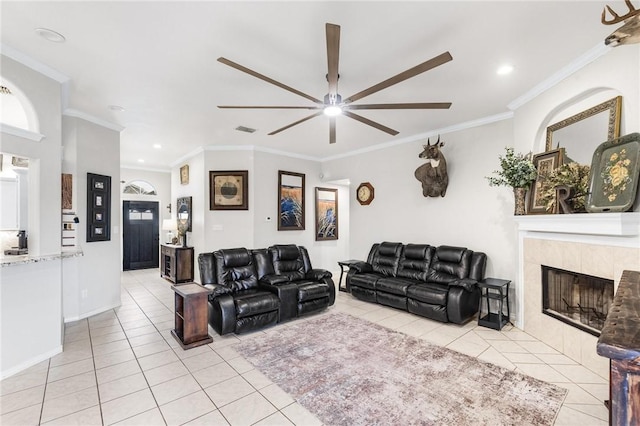 tiled living room featuring a tiled fireplace, ceiling fan, and ornamental molding