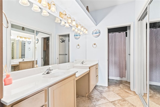 full bath with baseboards, two vanities, and a sink