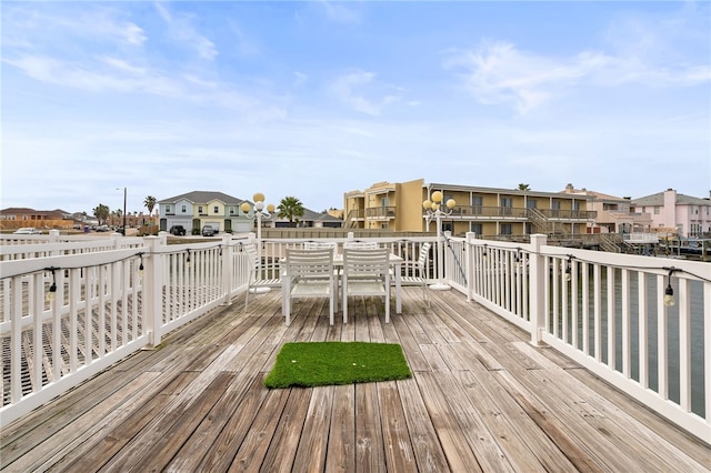 wooden deck featuring outdoor dining area and a residential view