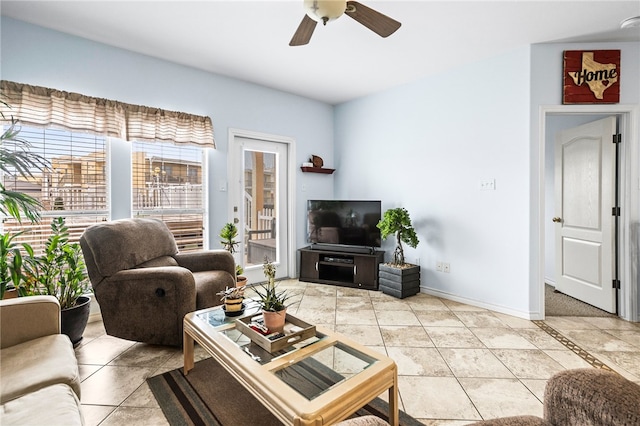 living area with ceiling fan and baseboards