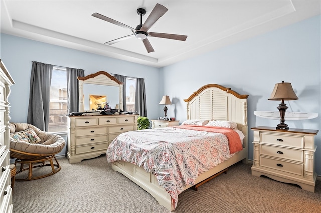 bedroom featuring light carpet, ceiling fan, and a tray ceiling