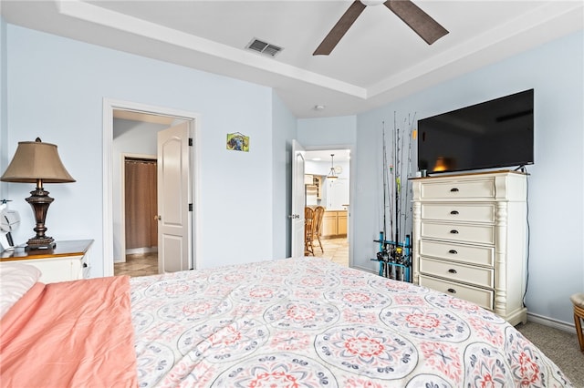 bedroom with light colored carpet, visible vents, a ceiling fan, ensuite bath, and baseboards