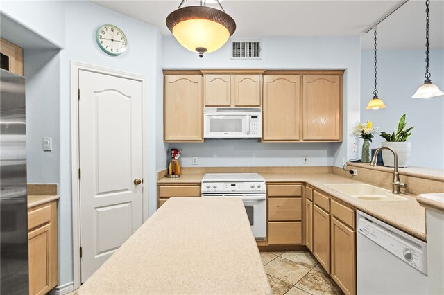 kitchen featuring light brown cabinets, white appliances, a sink, and visible vents