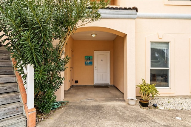 property entrance featuring a tiled roof and stucco siding