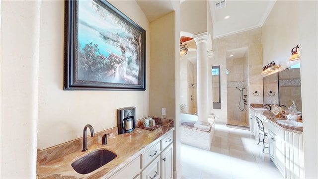 bathroom with tiled shower, tile patterned flooring, decorative columns, ornamental molding, and vanity