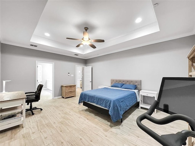 bedroom featuring crown molding, a tray ceiling, light hardwood / wood-style flooring, and ceiling fan