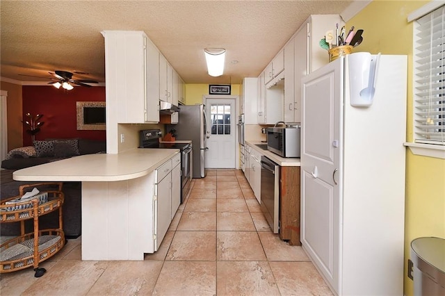 kitchen with kitchen peninsula, a textured ceiling, stainless steel appliances, ceiling fan, and white cabinets