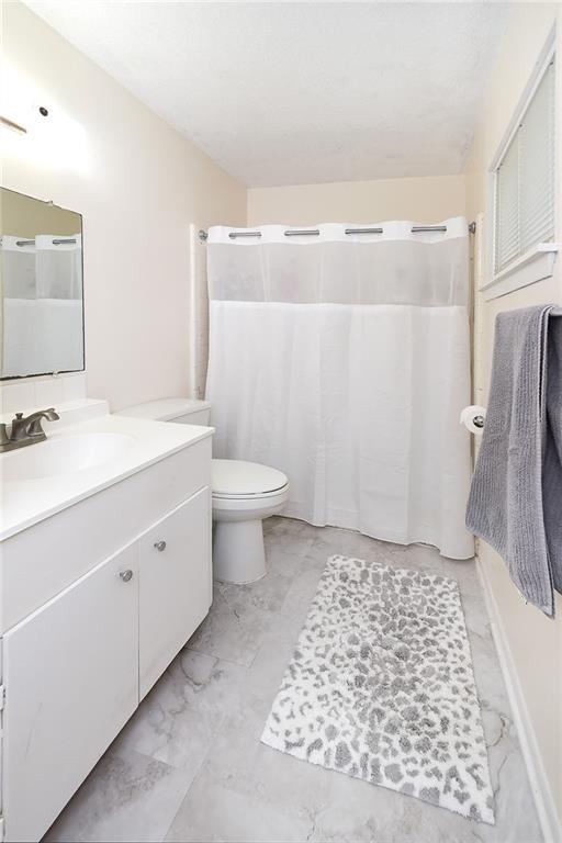 bathroom featuring vanity, toilet, and walk in shower