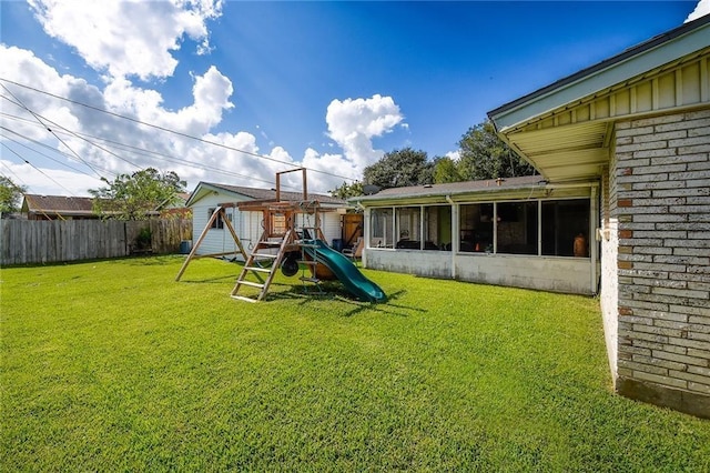 view of playground with a yard and a sunroom