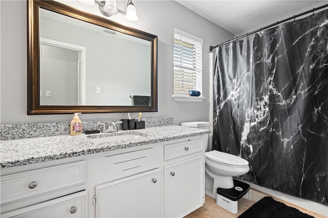 3029 White Bird Dr, Corpus Christi, TX 78415 - bathroom featuring vanity, a textured ceiling, toilet, wood finished floors, and curtained shower