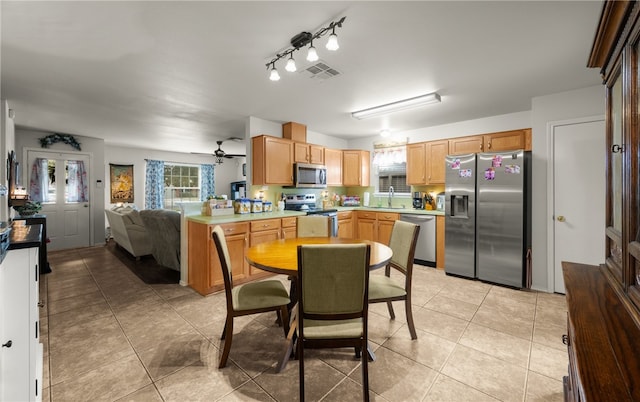 kitchen with ceiling fan, light tile patterned floors, appliances with stainless steel finishes, and sink