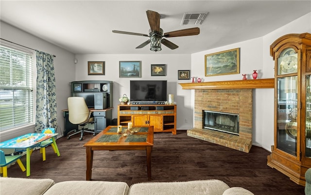 living room featuring a brick fireplace, dark hardwood / wood-style floors, and ceiling fan