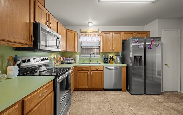 kitchen featuring sink, stainless steel appliances, and light tile patterned flooring