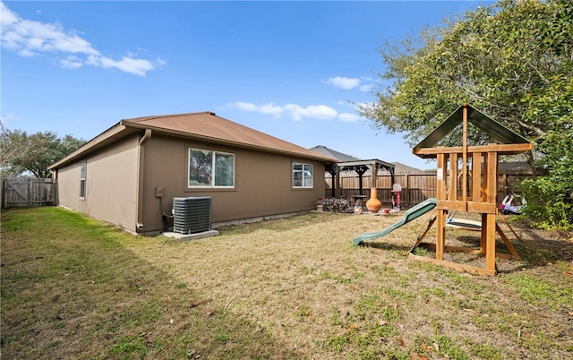 exterior space with central AC unit and a lawn