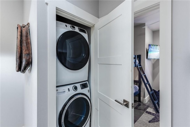 laundry area featuring stacked washer / drying machine