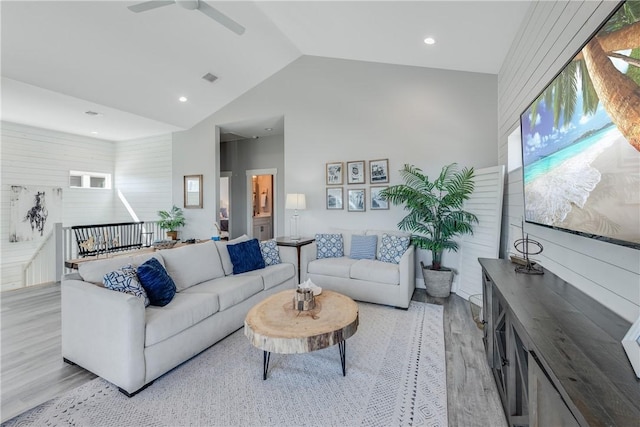 living room with light hardwood / wood-style floors, lofted ceiling, and ceiling fan