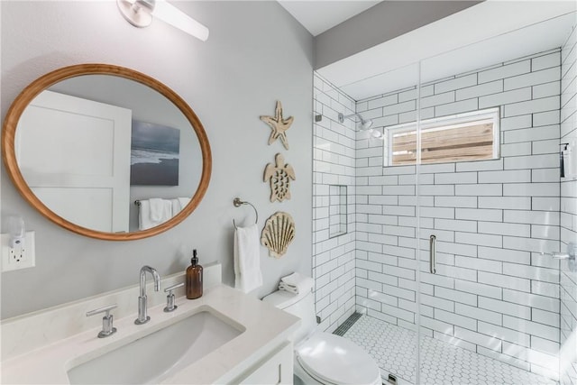 bathroom featuring a shower with shower door, vanity, and toilet