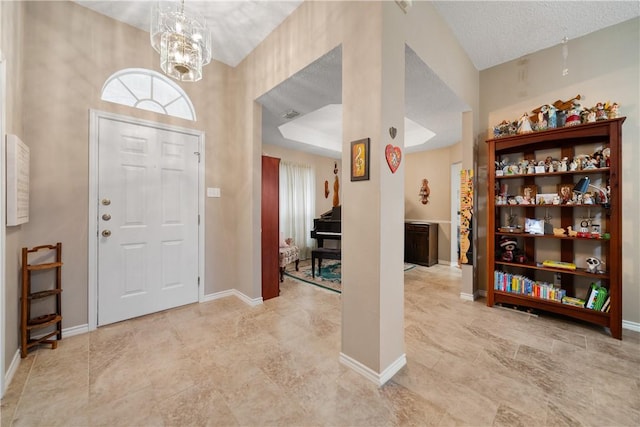 foyer entrance with a notable chandelier and a textured ceiling