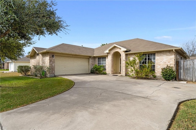 ranch-style house featuring a garage and a front lawn