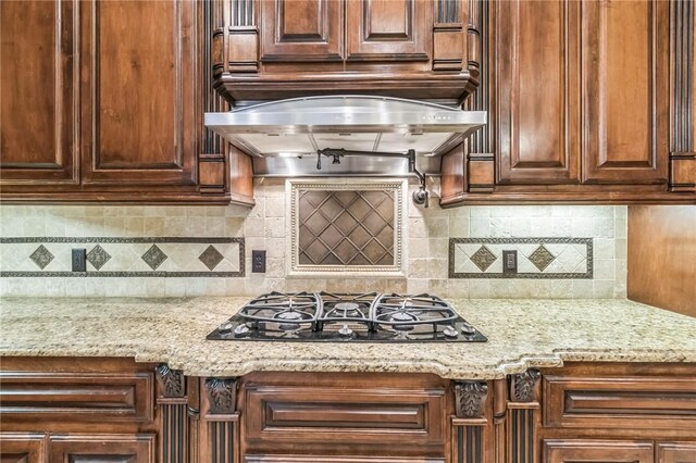 6522 Miranda Dr, Corpus Christi, TX 78414 - kitchen featuring black gas cooktop, under cabinet range hood, light stone counters, and decorative backsplash