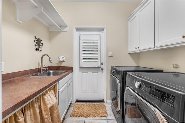 clothes washing area featuring washer and dryer, sink, light tile patterned floors, and cabinets