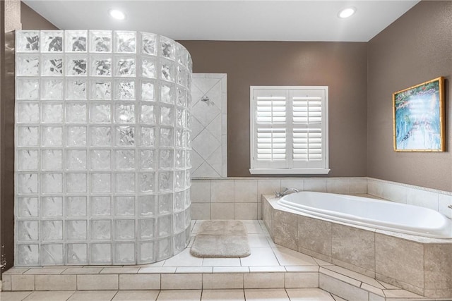 bathroom with tile patterned flooring and shower with separate bathtub