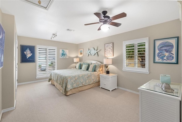 bedroom with ceiling fan, light carpet, and multiple windows