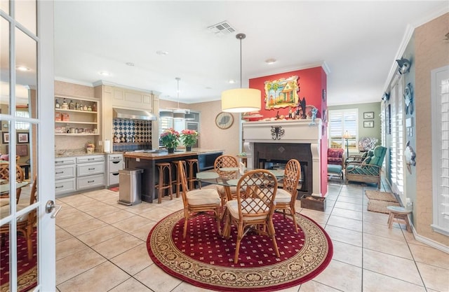 interior space featuring light tile patterned floors, ornamental molding, and a wealth of natural light